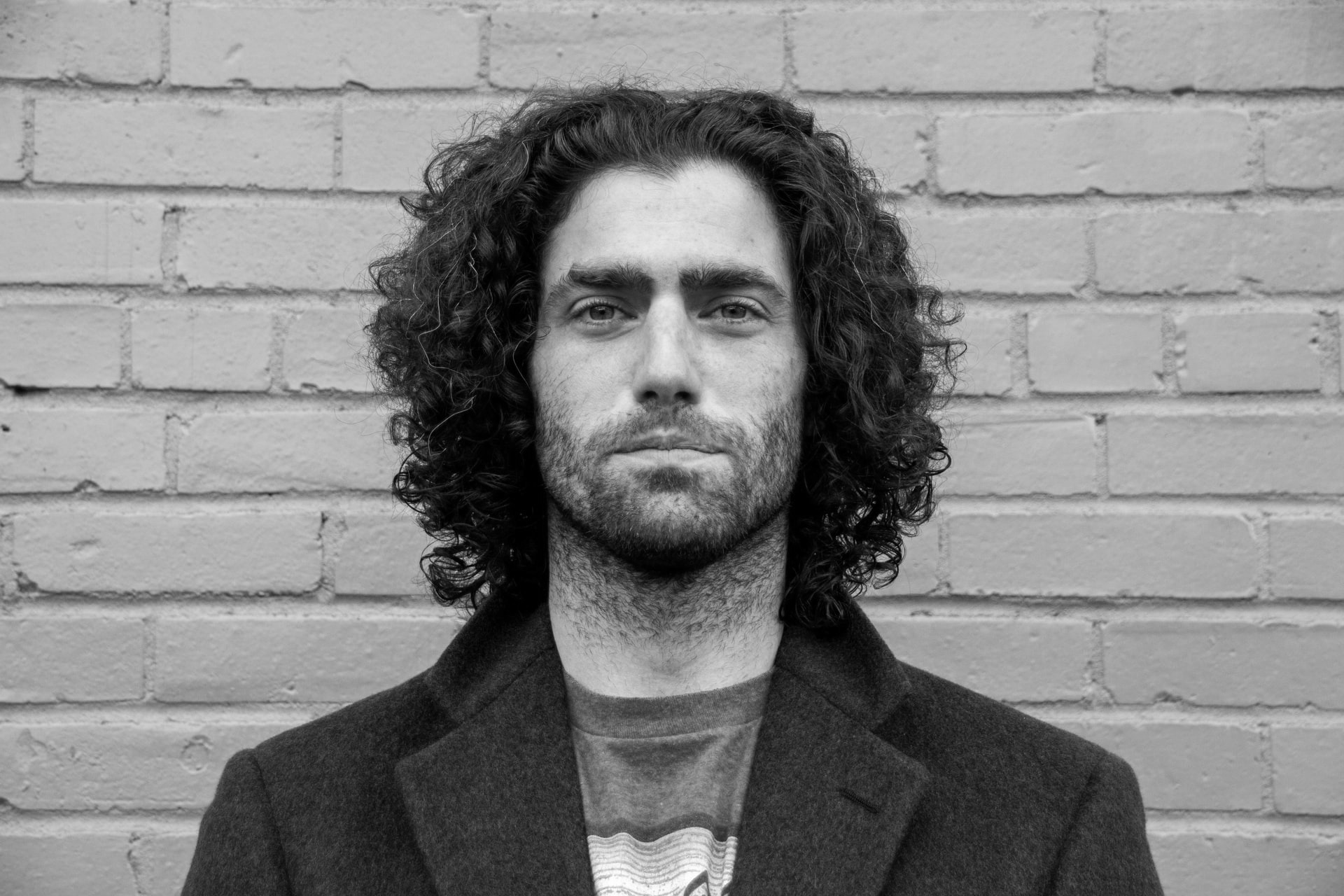 Кудрявый мужчина в пальто