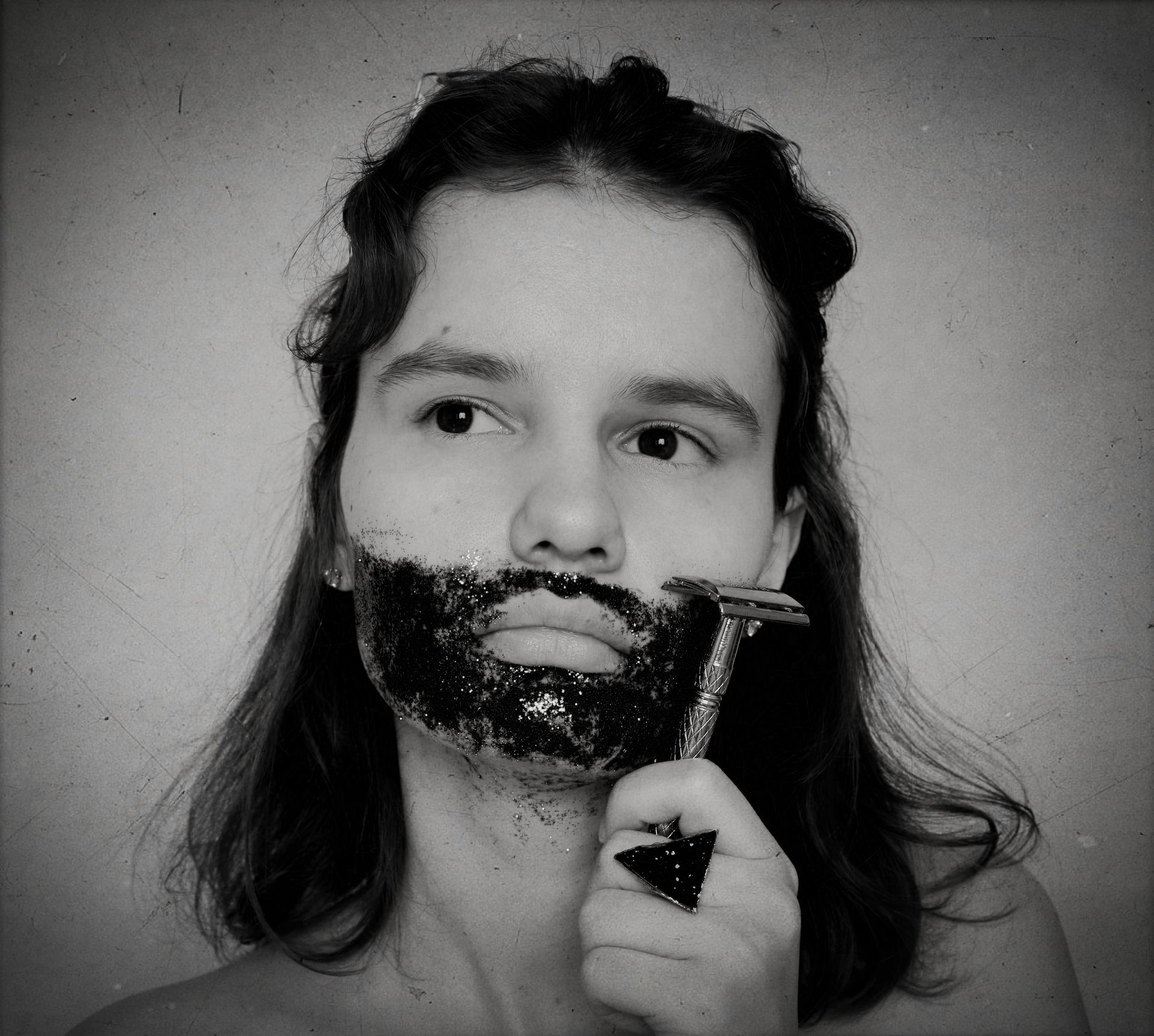 Девушка сбривает станком иллюстрированную бороду